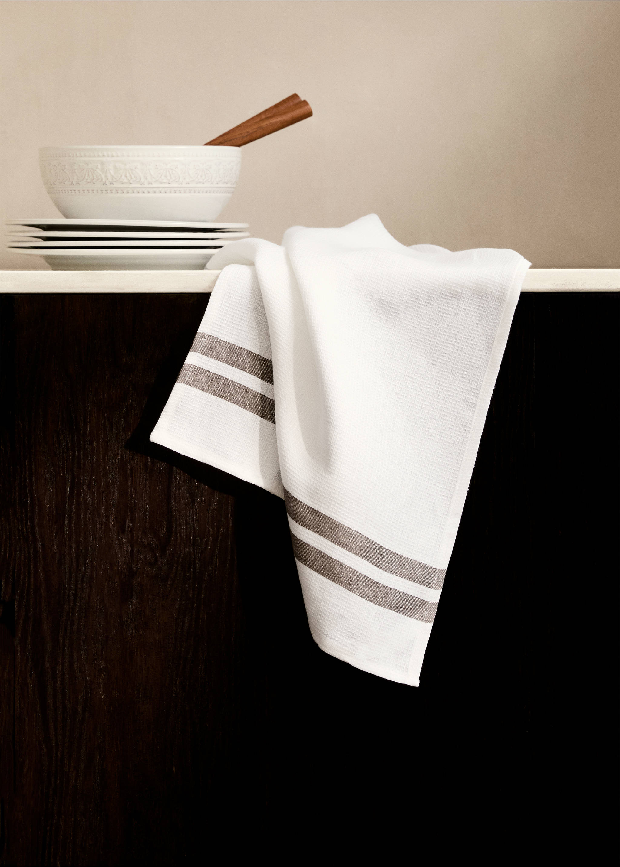 White kitchen towel with brown stripes draped over a counter., Sand. Ref: 87093308-00.