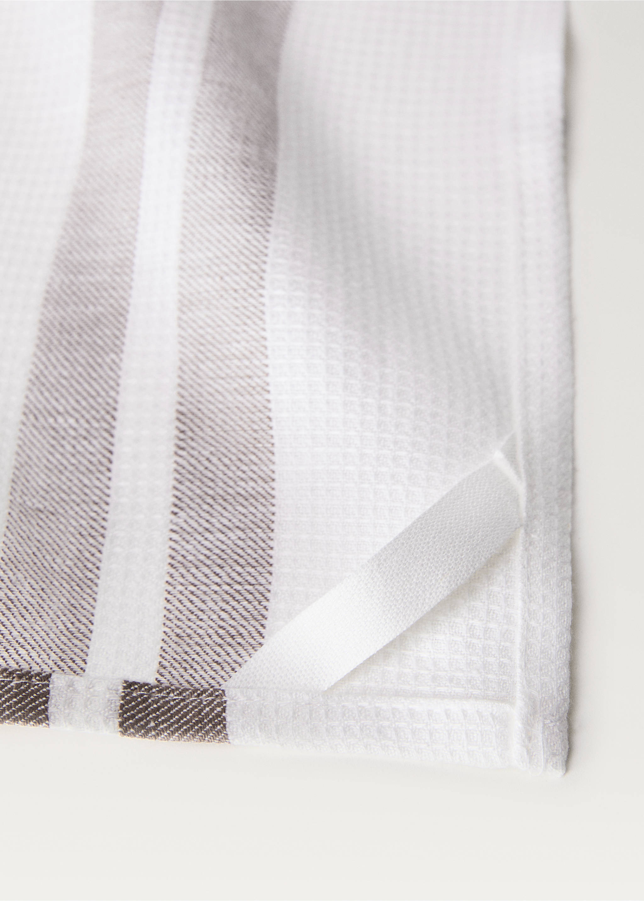 Close-up of a white waffle-texture kitchen towel with grey stripes and a hanging loop, Sand. Ref: 87093308-00.
