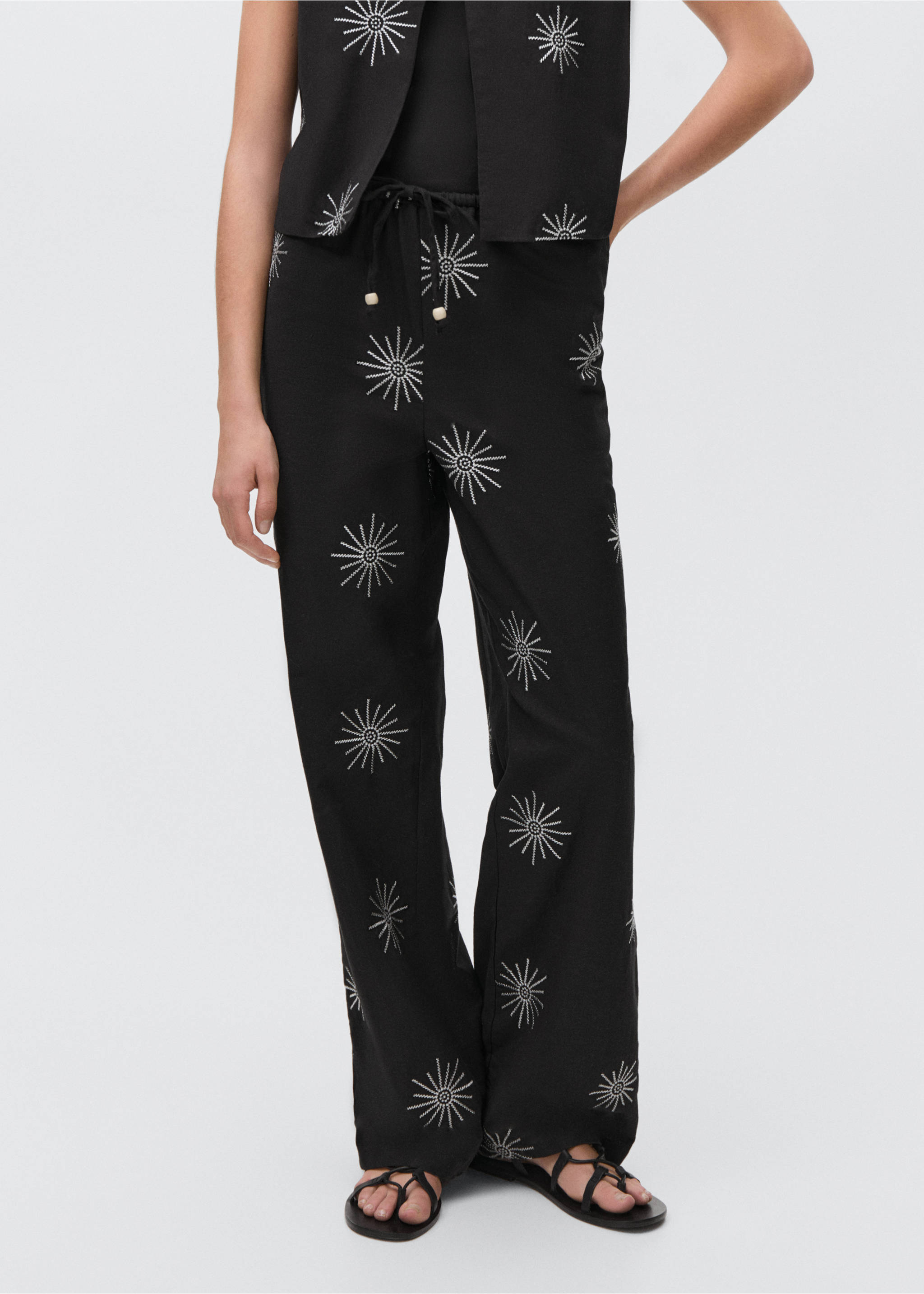Long trousers with embroidered details - Details of the article 1, Black. Ref: 87095725-00.