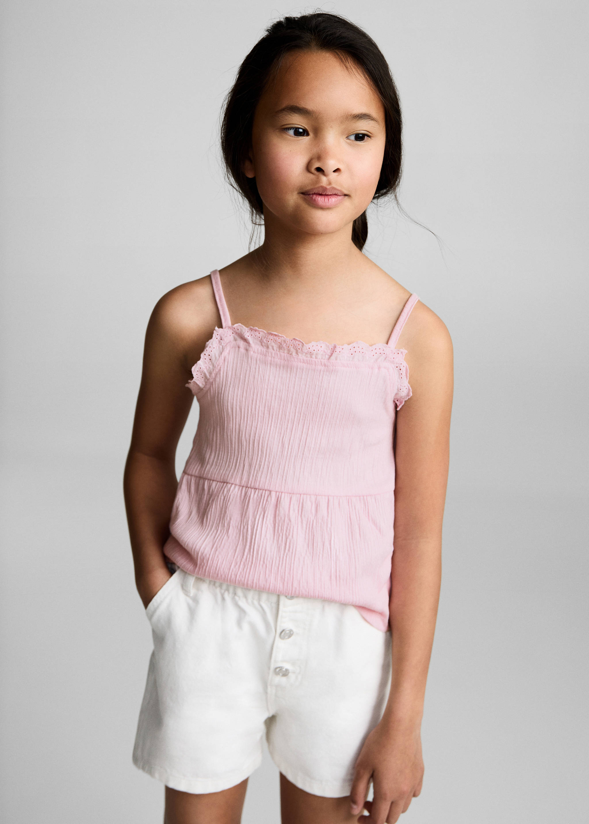Pink camisole top with thin straps and eyelet trim.