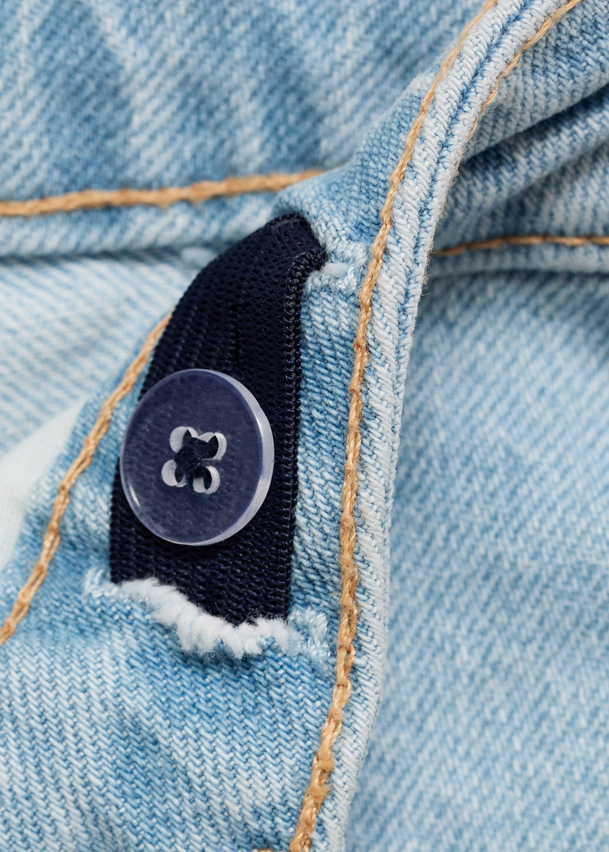 Close-up of light blue denim bermuda shorts featuring an adjustable inner elastic waistband.