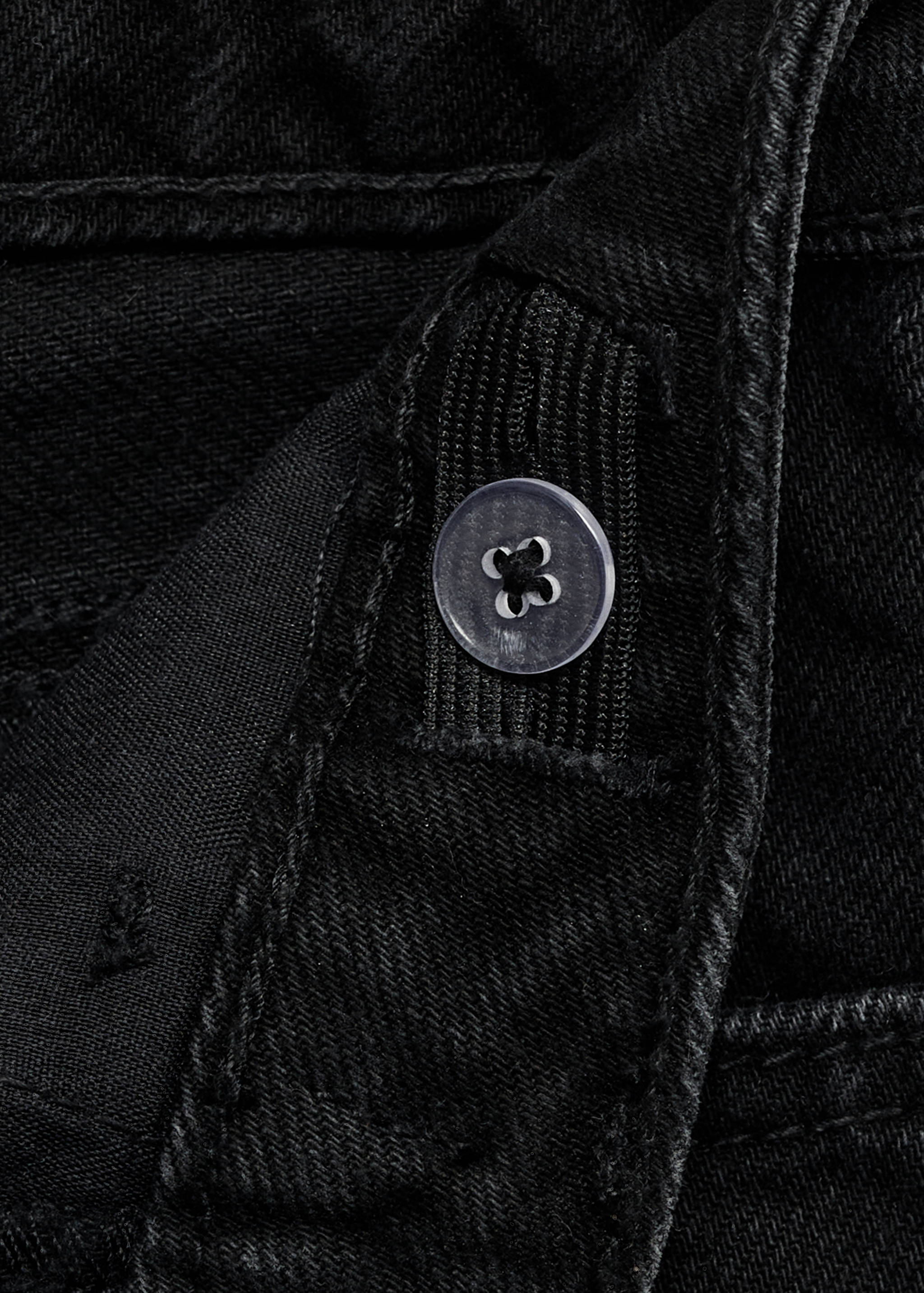 Close-up of the adjustable elasticated waistband detail on black denim bermuda shorts.